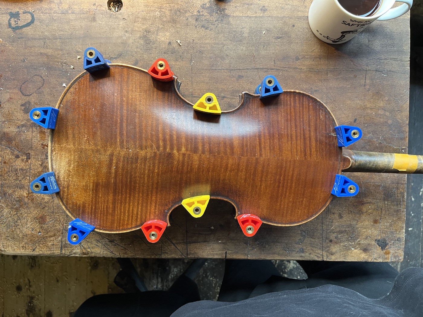 Violon maintenu par des serre-joints de luthier lors d'un recollement
